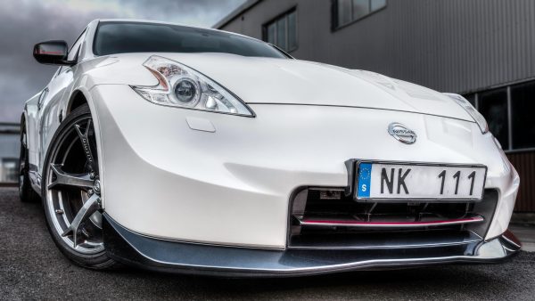 White Nissan sports car captured from a low angle, showcasing its sleek design.